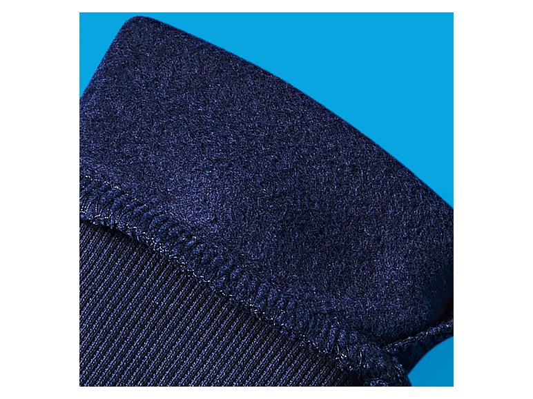 Close-up van donkerblauwe stof met een gestructureerd, licht pluizig oppervlak en zichtbare stiksels