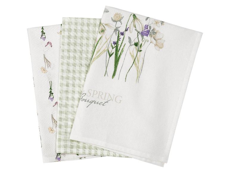 Drie theedoeken: één met bloemenprint en de tekst 'SPRING Bouquet', één groen geruit en één met verspreide bloemen.