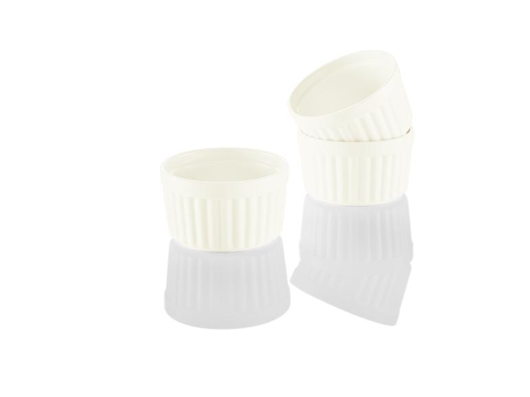 Drie witte keramische bakvormen voor individuele porties.