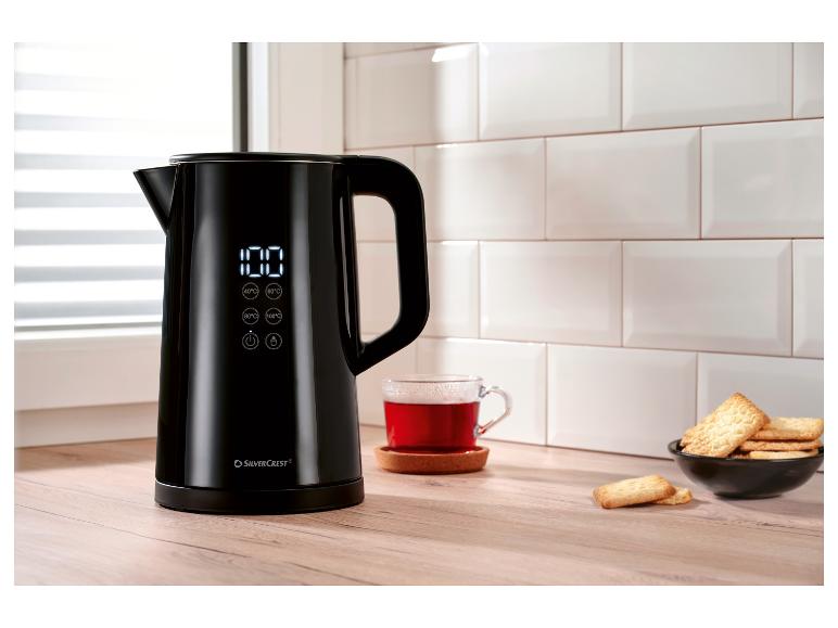 Zwarte SilverCrest waterkoker met digitaal display, kopje thee en koekjes in de keuken.