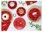 Rood servies met stippen, koffie, cake en bloemen op een tafel.