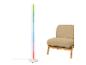 Kleurrijke LED vloerlamp naast een beige fauteuil.