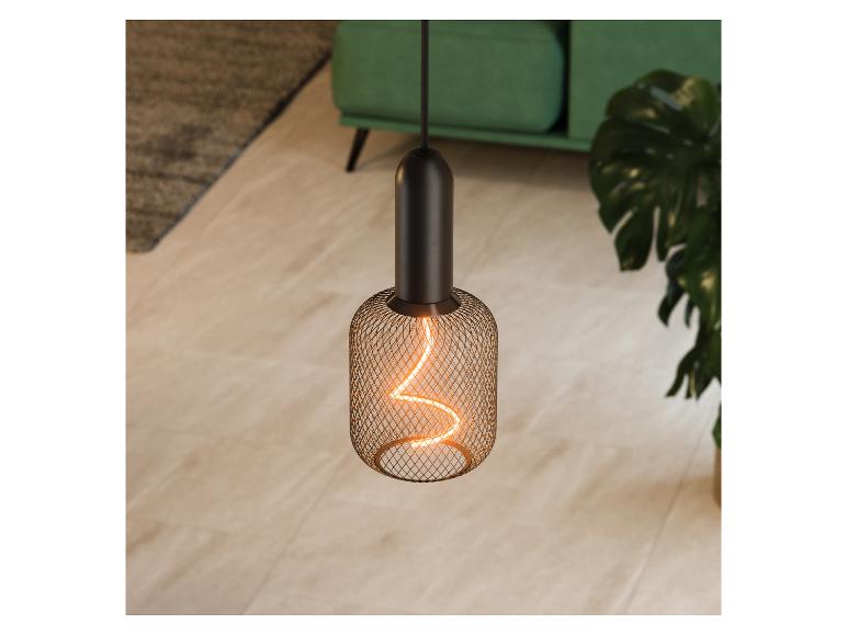 Hanglamp met filamentlamp in een woonkamer met een groene bank en plant.