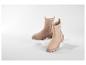 Twee beige suède Chelsea boots met dikke zolen op witte dozen.