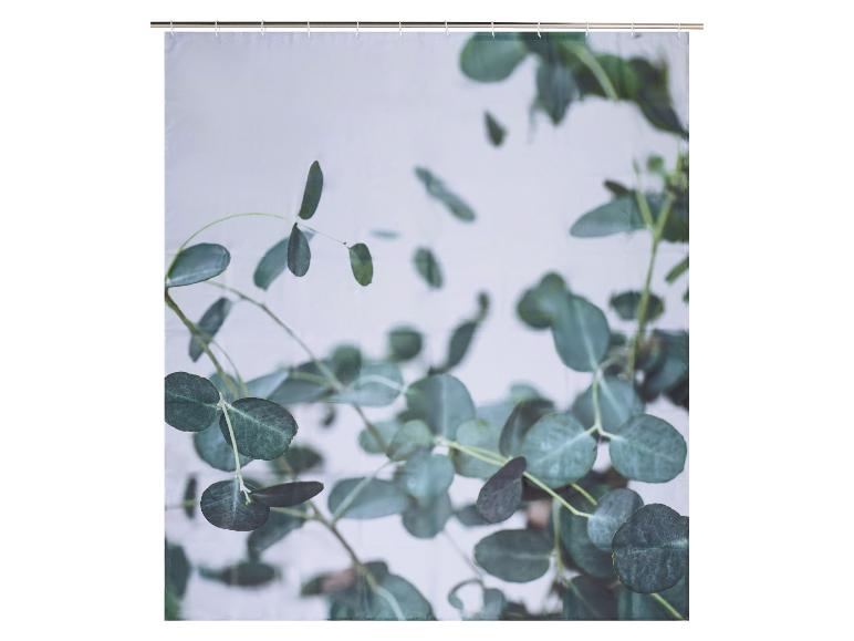 Douchegordijn met een patroon van groene eucalyptusbladeren op een lichte achtergrond.