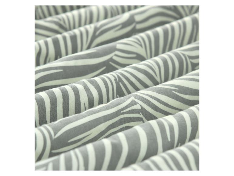 Close-up van een grijs en wit zebraprint stof met zachte plooien.