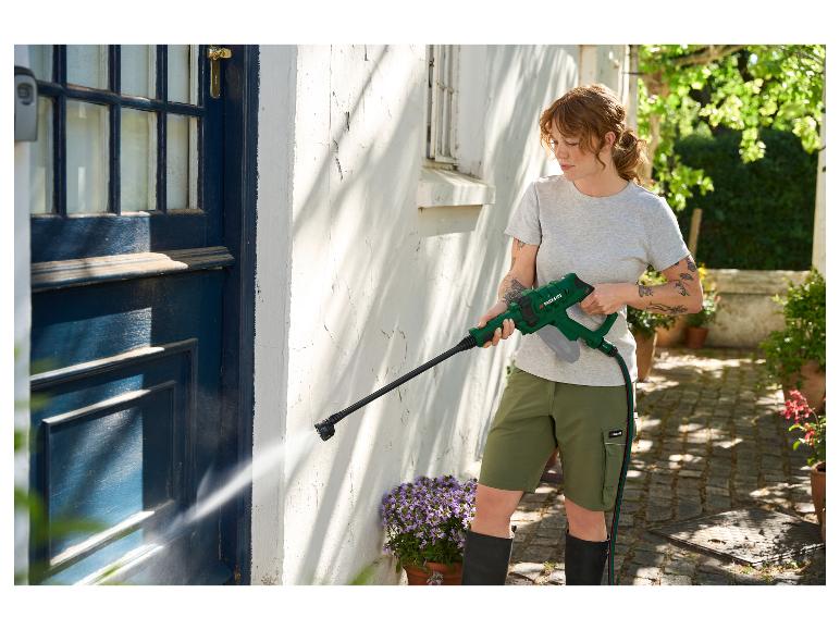Vrouw met PARKSIDE hogedrukreiniger reinigt muur en deur.