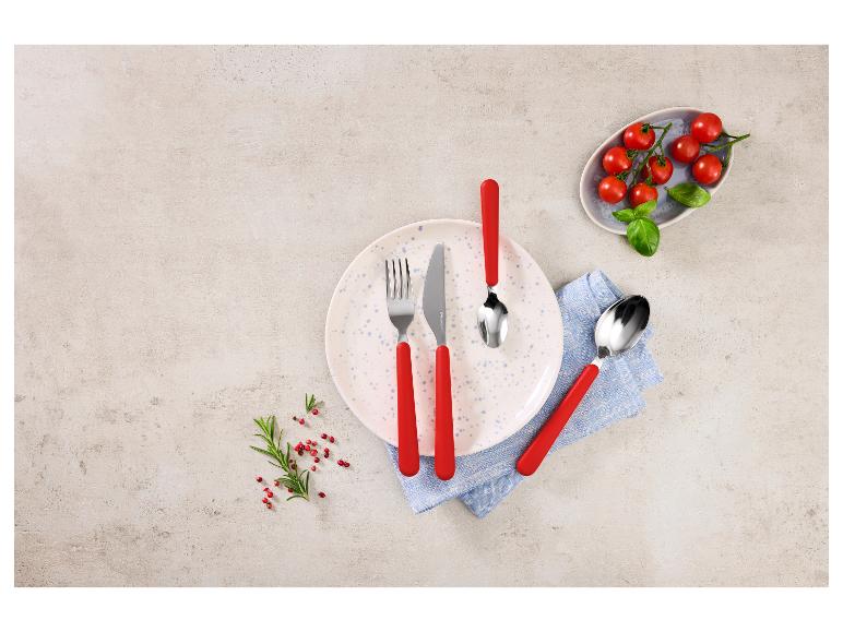 Bestekset met rode handvatten, bord, servet, cherrytomaten en kruiden.