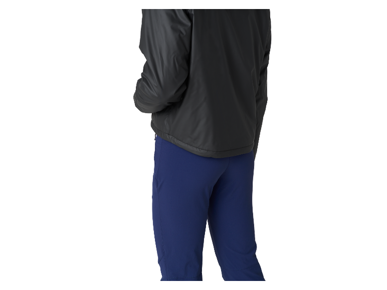 Een vrouw draagt een zwart jack en een blauwe broek.