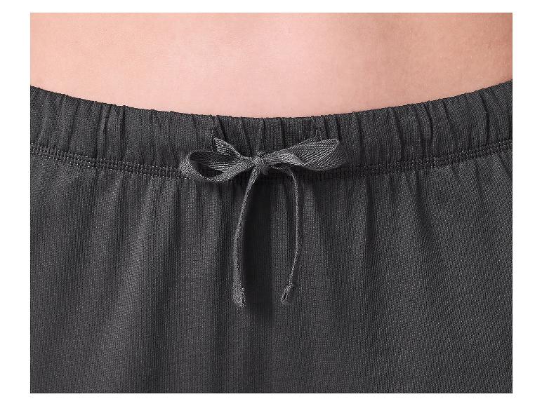 Close-up van het middel van een persoon die een donkergrijze joggingbroek met trekkoord draagt.