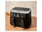 Zwarte dubbele airfryer met friet en kipvleugels op de achtergrond.