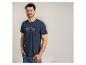 Man in een marineblauw T-shirt met de tekst 'SPORTS CLUB Love for Leisure' en jeans.