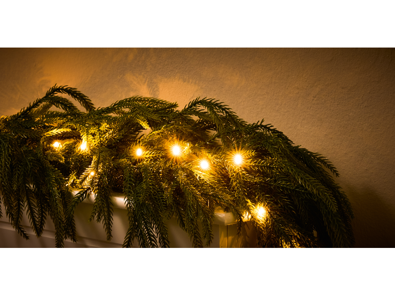 Kerstslinger met warmwitte LED-verlichting op een lichte achtergrond.