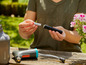 Een persoon houdt Duracell-batterijen en een Gardena-watergeefsysteem vast.