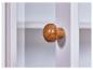 Houten knop op wit meubel.