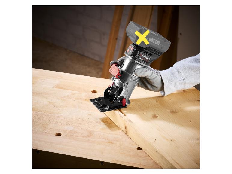 Een persoon met handschoenen gebruikt een draadloze mini-cirkelzaag om een houten plank te zagen.