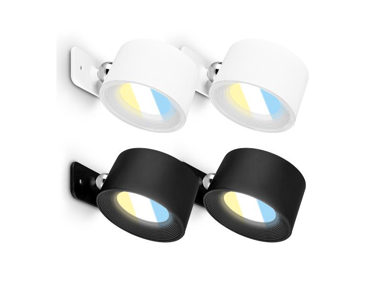 Twee paar wandgemonteerde spotlights, één wit en één zwart, met verstelbaar licht.