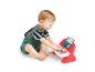 Blije baby zit en speelt met een interactieve speelgoedpiano.