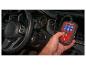 Een hand houdt een Ultimate Speed OBD2-scanner vast in een auto.