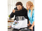 Een man proeft een gerecht uit een Thermomix-keukenmachine.