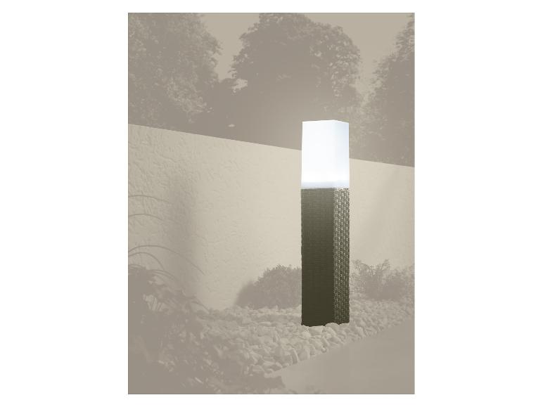 Tuinlamp met gevlochten voet en witte kap, omringd door kiezels.