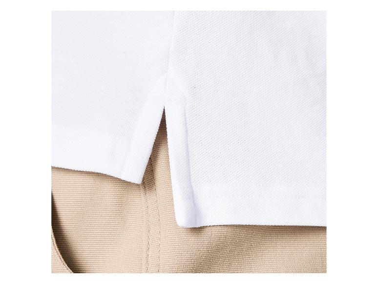 Wit poloshirt met zijsplit aan de zoom, gedragen met een kaki broek.