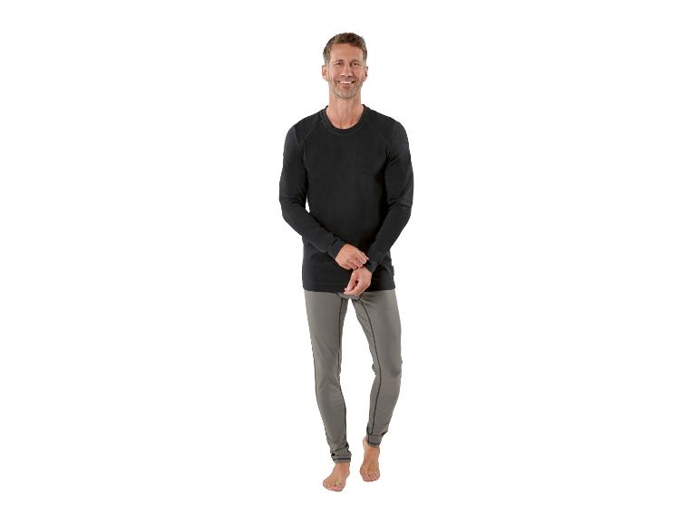 Man in een zwart shirt met lange mouwen en grijze joggingbroek.