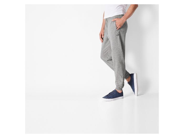 Man draagt grijze joggingbroek met K-Swiss sneakers.