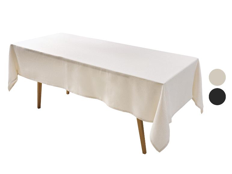 Rechthoekig crèmekleurig tafelkleed met twee kleurstalen op een houten tafel