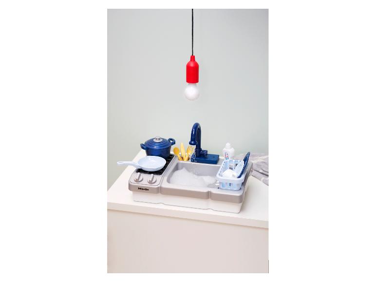 Een Miele speelkeuken set met een gootsteen, fornuis en kookaccessoires.