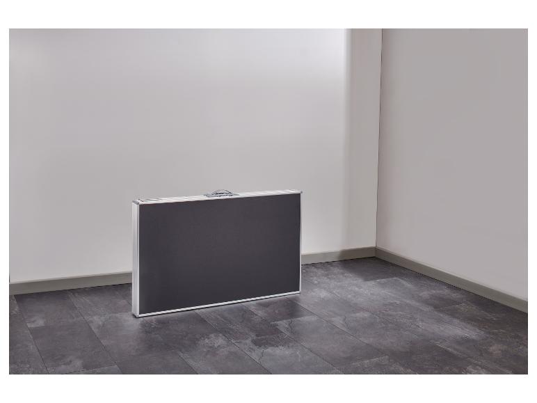 Zwarte en zilveren klaptafel op een donkere tegelvloer in een kamerhoek.