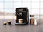 Een Philips koffiezetapparaat met een kop cappuccino, espresso en koffiebonen.