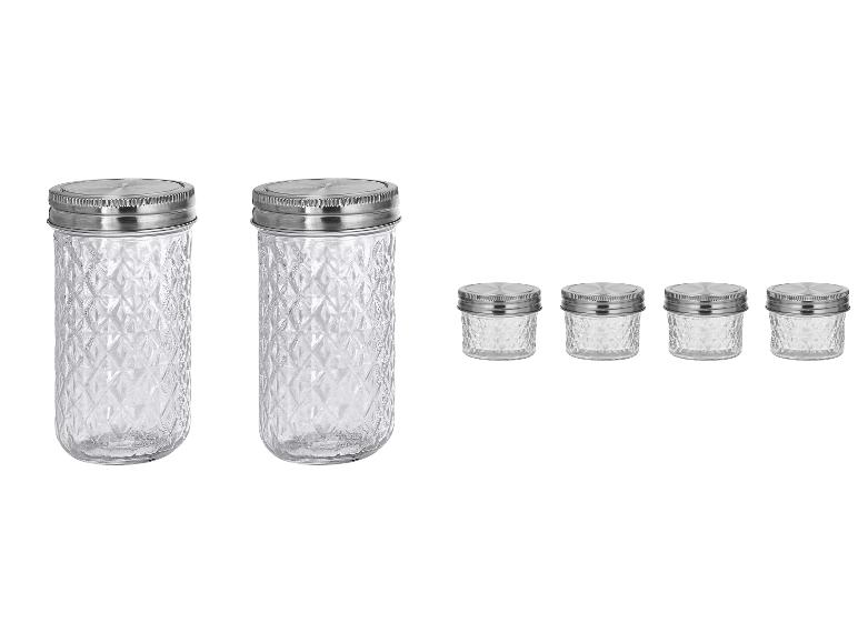 Twee hoge en vier kleine glazen potten met metalen deksels, voorzien van een diamantpatroon.