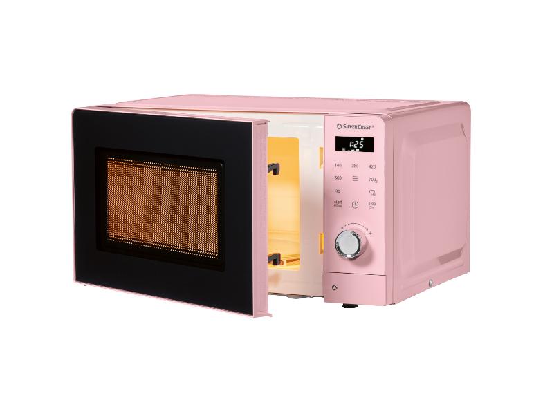 Roze magnetron met open deur, toont het verlichte interieur en het bedieningspaneel.