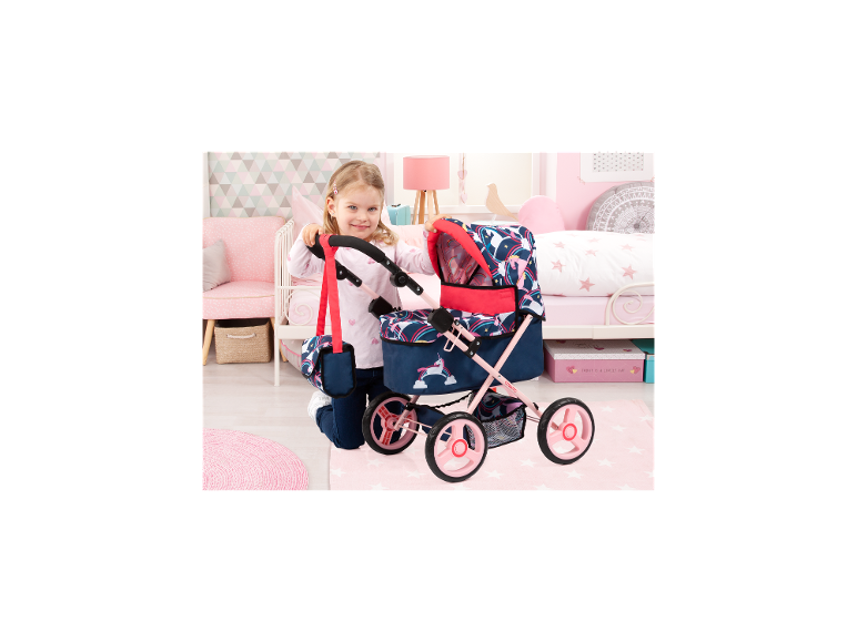Meisje met BAYER DESIGN poppenwagen Trendy Unicorn Cosatto in een kinderkamer.