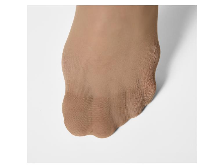 Voet in een beige panty, met tenen zichtbaar door de transparante stof.