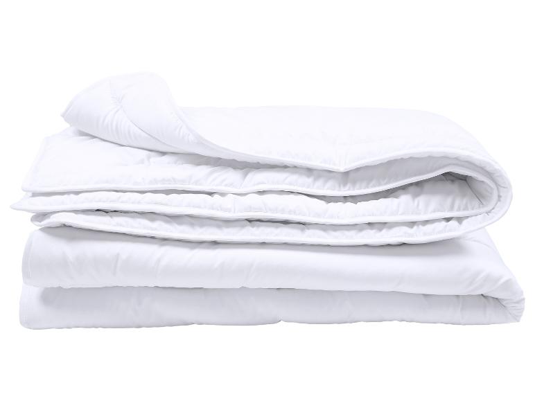 Wit gevouwen dekbed met stiksels op een witte achtergrond