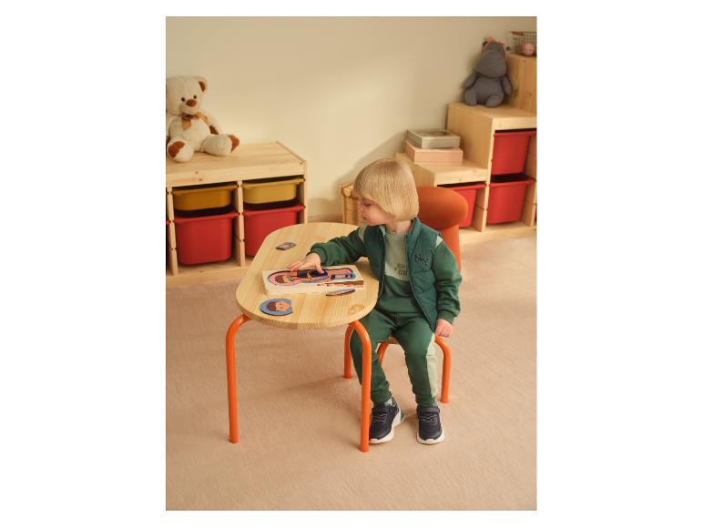 Een kind speelt met een LUPILU® houten lichaamspuzzel aan een kleine tafel.