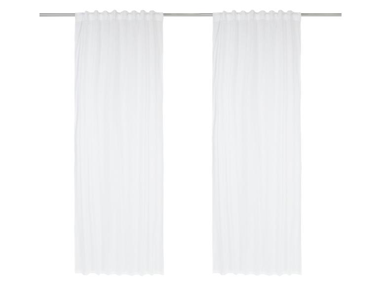 Witte gordijnen op een metalen stang.