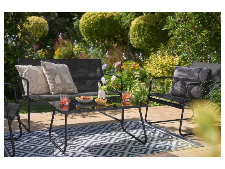 Tuinmeubelset met tafel, bank en stoelen, inclusief kussens en een buitenkleed.