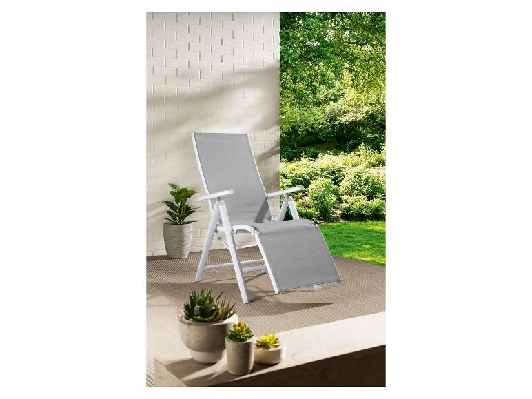 Een witte ligstoel met een grijze bekleding op een terras.