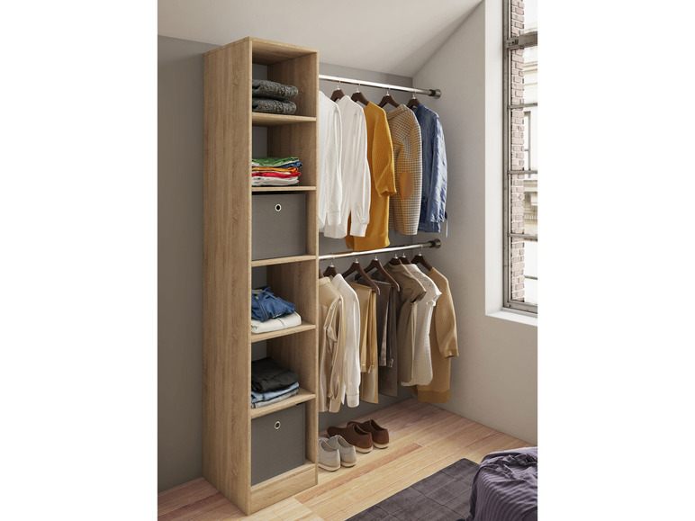 Een houten kledingkast met planken en een kledingroede, met kleding en schoenen er in