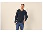 Man in een donkerblauw shirt met lange mouwen en knopen en jeans, lachend omhoogkijkend.