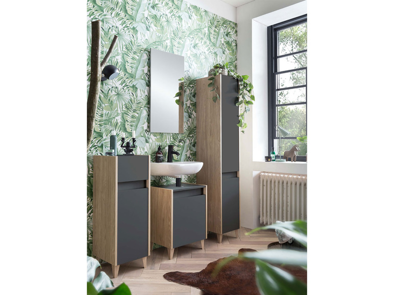 Badkamermeubel met spiegel, wastafel en twee kasten in een tropische setting.