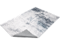 Abstract grijs en wit vloerkleed met getextureerd patroon, toont de onderkant