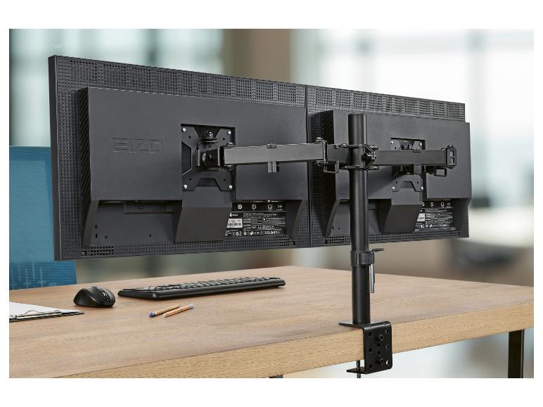 Twee monitoren op een bureau met een dubbele monitorbeugel, toetsenbord, muis en klembord.