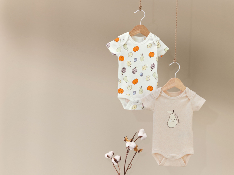 Twee babyrompertjes met fruitprint, een met peren en de andere met een perenmotief.