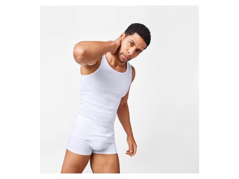 Man draagt een wit tanktop en witte boxershort.