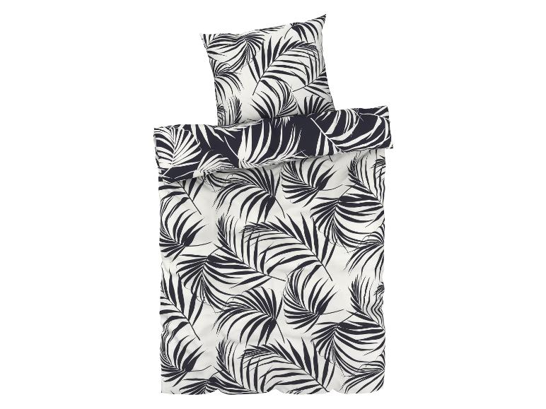 Een dekbedovertrek en kussensloop met tropisch palmbladerenpatroon.