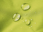 Waterdruppels op een lichtgroen, waterdicht textiel.